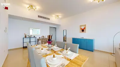 a dining room with a long table and chairs at bnbmehomes - DEC Tower 1 in Dubai