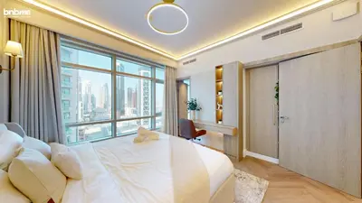 a bedroom with a large bed and a large window at bnbmehomes - The Lofts Central in Dubai