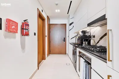 a kitchen with a stove and a hallway at bnbmehomes - Trillionaire Residences By Binghatti in Dubai