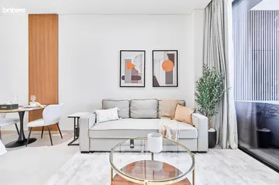 a living room with a couch and a table at bnbmehomes - Trillionaire Residences By Binghatti in Dubai