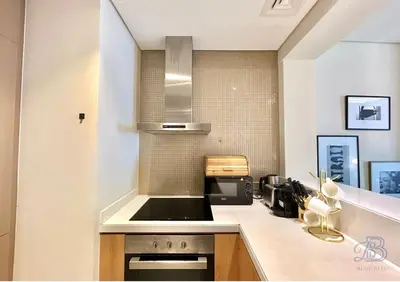 a kitchen with a sink and a stove top oven at 1 Bedroom Apartment in Paramount Tower - A in Dubai