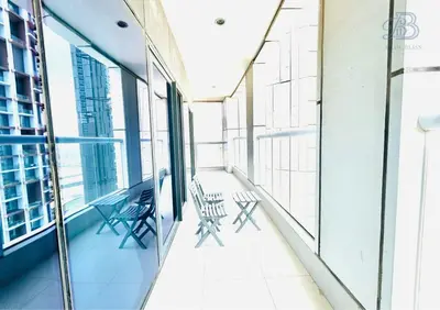 a balcony with chairs and tables in a building at 1 Bedroom Apartment in Paramount Tower - A in Dubai