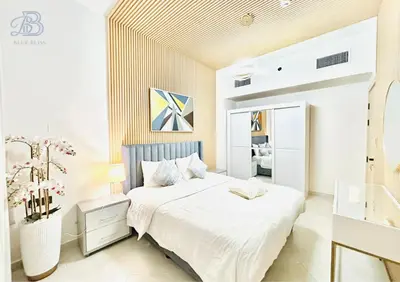a white bedroom with a bed and a mirror at 1 Bedroom Apartment in Al Jaddaf - High-Floor with Dubai Skyline View in Dubai