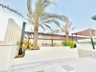 a courtyard with palm trees in a house at Stylish 1 Bedroom Apartment in the Heart of JVC in Dubai