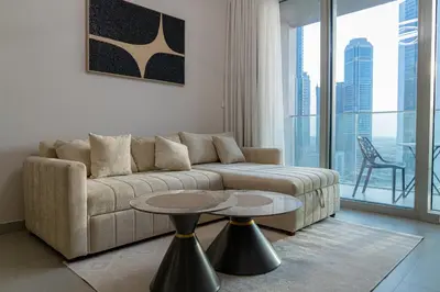 a living room with a couch and two tables at Elegant Downtown Escape 1BR w Balcony, Pool & Gym in Dubai