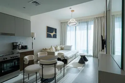 a living room with a couch and a table and chairs at Elegant Downtown Escape 1BR w Balcony, Pool & Gym in Dubai