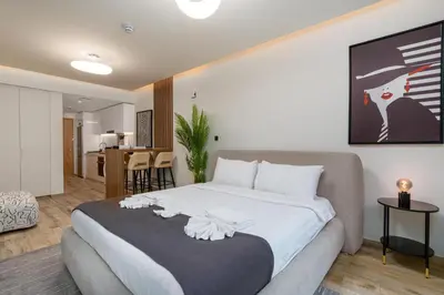 a bedroom with a large bed and a living room at Urban Studio - Business Bay in Dubai