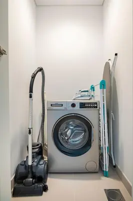 a washing machine and a vacuum in a room at The Grand Luxury Residential I1Bedroom I High Floor I Water View I Tennis & Badminton Courts I Rooftop Lounge in Dubai