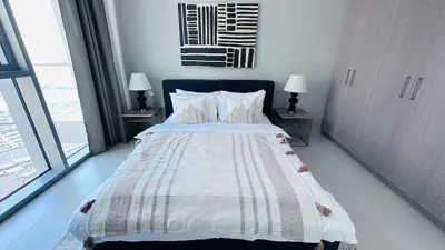 a bedroom with a large bed with two night stands at The Grand Luxury Residential I1Bedroom I High Floor I Water View I Tennis & Badminton Courts I Rooftop Lounge in Dubai