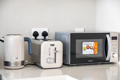 a microwave next to a toaster and a coffee maker at The Grand Luxury Residential I1Bedroom I High Floor I Water View I Tennis & Badminton Courts I Rooftop Lounge in Dubai