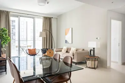 a living room with a glass table and a couch at The Grand Luxury Residential I1Bedroom I High Floor I Water View I Tennis & Badminton Courts I Rooftop Lounge in Dubai