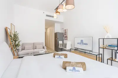 a room with a bed with two towels on it at Bright Modern Studio in the Heart of JVC in Dubai