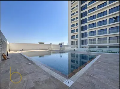 a large building with a swimming pool in front of a building at Bookable - 1 Bedroom Binghatti Crescent in Dubai