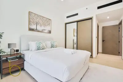 a white bedroom with a large bed and a sliding door at Bookable - 1 Bedroom Binghatti Crescent in Dubai