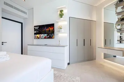 a white bedroom with a white bed and a mirror at 2 Bedroom Apartment in Business Bay Gym, Pool & View in Dubai