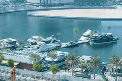 a group of boats docked in a river with palm trees at 2 Bedroom Apartment in Business Bay Gym, Pool & View in Dubai