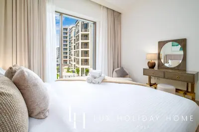 a bedroom with a large white bed with a window at LUX The Dubai Creek Beach Suite 2 in Dubai