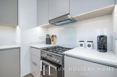 a kitchen with a stove and white counter tops at LUX The Dubai Creek Beach Suite 2 in Dubai