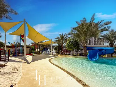 a swimming pool with a slide in a resort at LUX The Dubai Creek Beach Suite 2 in Dubai