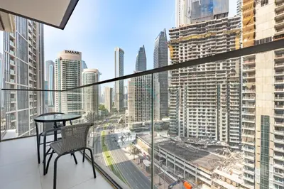 a balcony with a table and a view of a city at Boulevard Views, Steps from Burj Khalifa & Dubai Mall, Near Metro Station and Few Mins Drive to Dubai Marina - Burj Crown, Downtown Dubai by Deluxe Holiday Homes in Dubai