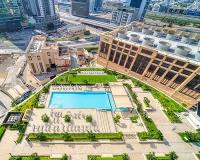 an aerial view of a building with a pool at Boulevard Views, Steps from Burj Khalifa & Dubai Mall, Near Metro Station and Few Mins Drive to Dubai Marina - Burj Crown, Downtown Dubai by Deluxe Holiday Homes in Dubai