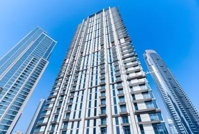 two tall buildings in front of a blue sky at Boulevard Views, Steps from Burj Khalifa & Dubai Mall, Near Metro Station and Few Mins Drive to Dubai Marina - Burj Crown, Downtown Dubai by Deluxe Holiday Homes in Dubai