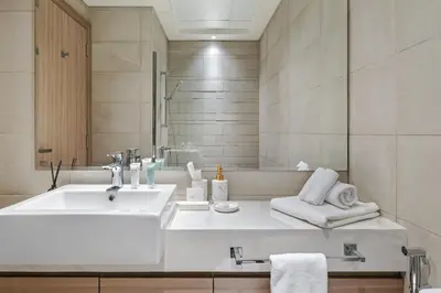 a white bathroom with a sink and a mirror at 1BR Azizi Riviera 44 City Skyline View in Dubai