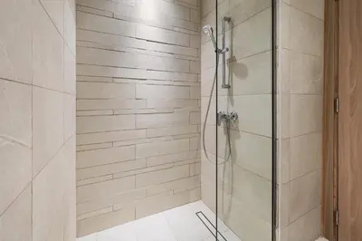 a shower with a glass door in a bathroom at 1BR Azizi Riviera 44 City Skyline View in Dubai