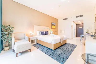 a bedroom with a large bed and a chair at City View Studio on High Floor, Steps from Metro, Beside Water Canal, Quick Downtown Access, The Cosmopolitan, Business Bay by Deluxe Holiday Homes in Dubai