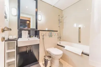 a bathroom with a toilet and a sink and a shower at City View Studio on High Floor, Steps from Metro, Beside Water Canal, Quick Downtown Access, The Cosmopolitan, Business Bay by Deluxe Holiday Homes in Dubai
