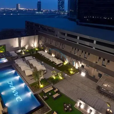 an aerial view of a building with a swimming pool at City View Studio on High Floor, Steps from Metro, Beside Water Canal, Quick Downtown Access, The Cosmopolitan, Business Bay by Deluxe Holiday Homes in Dubai
