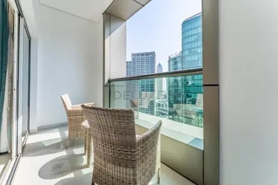 a balcony with wicker chairs and a view of the city at City View Studio on High Floor, Steps from Metro, Beside Water Canal, Quick Downtown Access, The Cosmopolitan, Business Bay by Deluxe Holiday Homes in Dubai