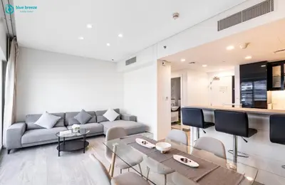 a living room with a couch and a table at Blue Breeze - Stunning 1BR with Canal & Pool Views in Dubai