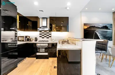a kitchen with a sink and a stove at Blue Breeze - Stunning 1BR with Canal & Pool Views in Dubai
