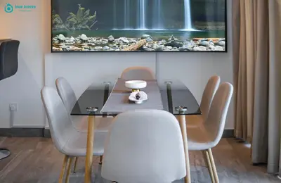 a dining room with a glass table and chairs at Blue Breeze - Stunning 1BR with Canal & Pool Views in Dubai