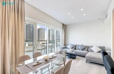 a living room with a couch and a table at Blue Breeze - Stunning 1BR with Canal & Pool Views in Dubai