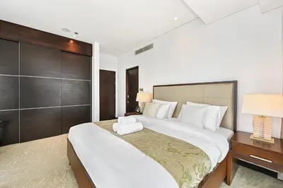 a bedroom with a large bed with white sheets at One Bed Marina View on 34th floor in Dubai