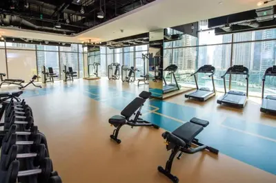 a gym with rows of treadmills and exercise bikes at Marina Gate 2 - High Rise One Bed with Marina View in Dubai