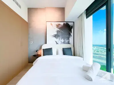 a bedroom with a large bed with a large window at Breathtaking Studio with Balcony & Stunning Views in Dubai
