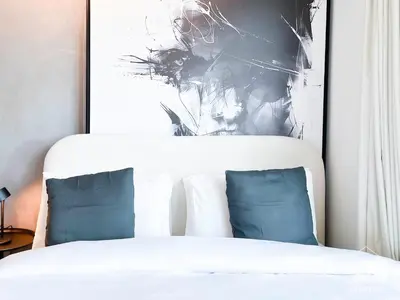 a white bed with two blue pillows in a bedroom at Breathtaking Studio with Balcony & Stunning Views in Dubai