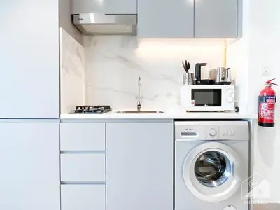 a kitchen with a washing machine and a microwave at Breathtaking Studio with Balcony & Stunning Views in Dubai