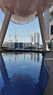 a swimming pool in a building with cranes at Opalz by danube in Dubai