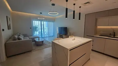 a kitchen and living room with a couch and a tv at Urban Sunset, Newly Renovated Central 1BR in Dubai