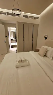 a white bed with two towels on top of it at Urban Sunset, Newly Renovated Central 1BR in Dubai