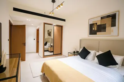 a bedroom with a large bed and a mirror at 2BR Luxury Baby, Gym & Pool in Dubai