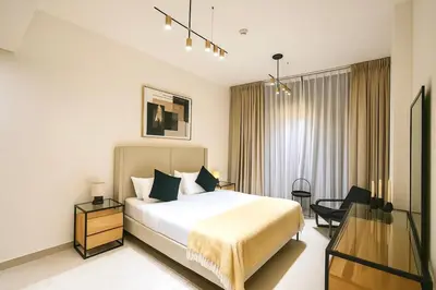 a hotel room with a bed and a desk at 2BR Luxury Baby, Gym & Pool in Dubai