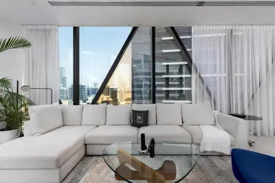 a living room with a white couch and a large window at Maison Privee - Sky-High Panoramic Apt with Iconic Burj Khalifa Vws in Dubai