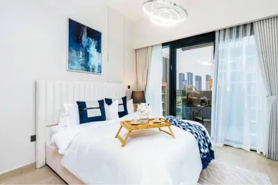 a bedroom with a bed with a table in it at Guest Favorite - Relaxed and Cozy Studio Near Racecourse in Dubai