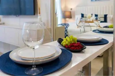 a table with two wine glasses and a bowl of fruit at Guest Favorite - Relaxed and Cozy Studio Near Racecourse in Dubai
