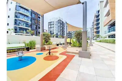 an apartment complex with a playground in a courtyard at Guest Favorite - Relaxed and Cozy Studio Near Racecourse in Dubai